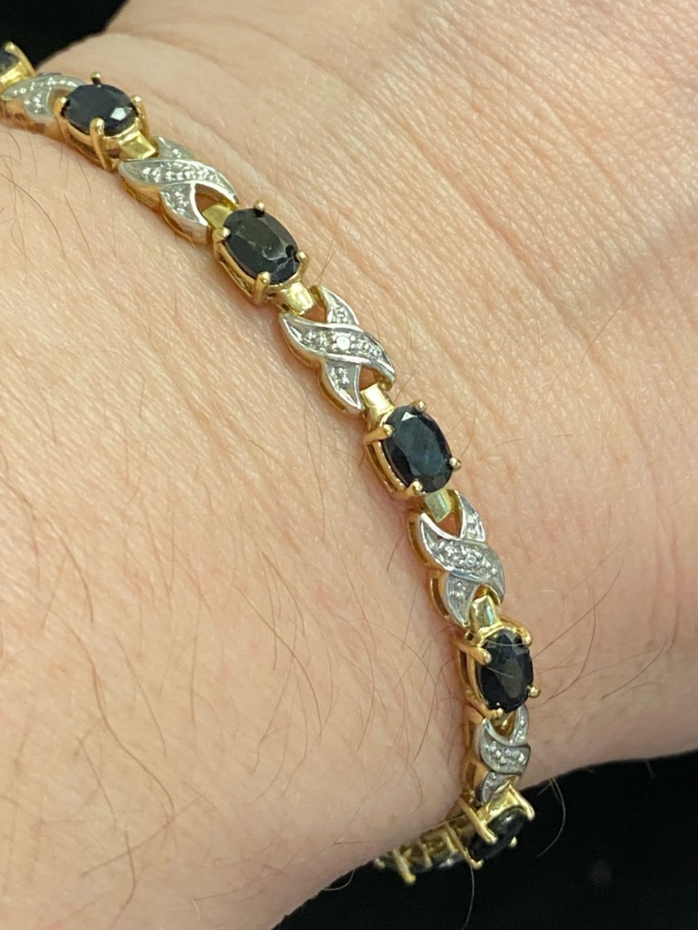 Gold-plated sterling silver X-O tennis bracelet featuring deep blue oval stones